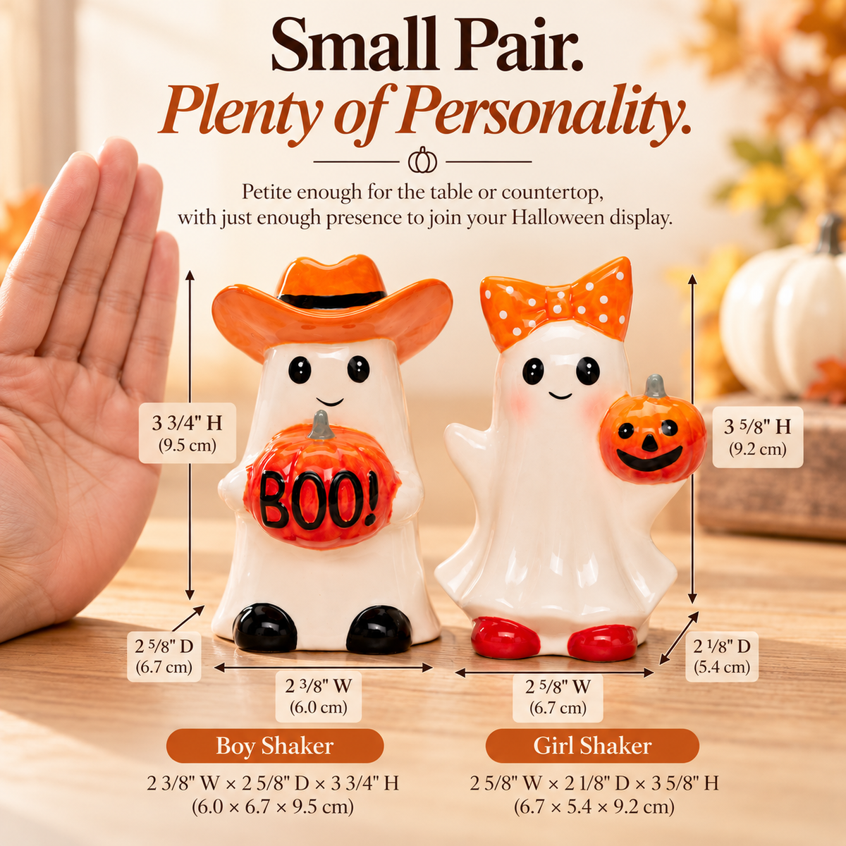Two small Halloween ghost figurines labeled Boy Shaker and Girl Shaker with measurement arrows and text on a wooden surface, alongside a human hand for scale.